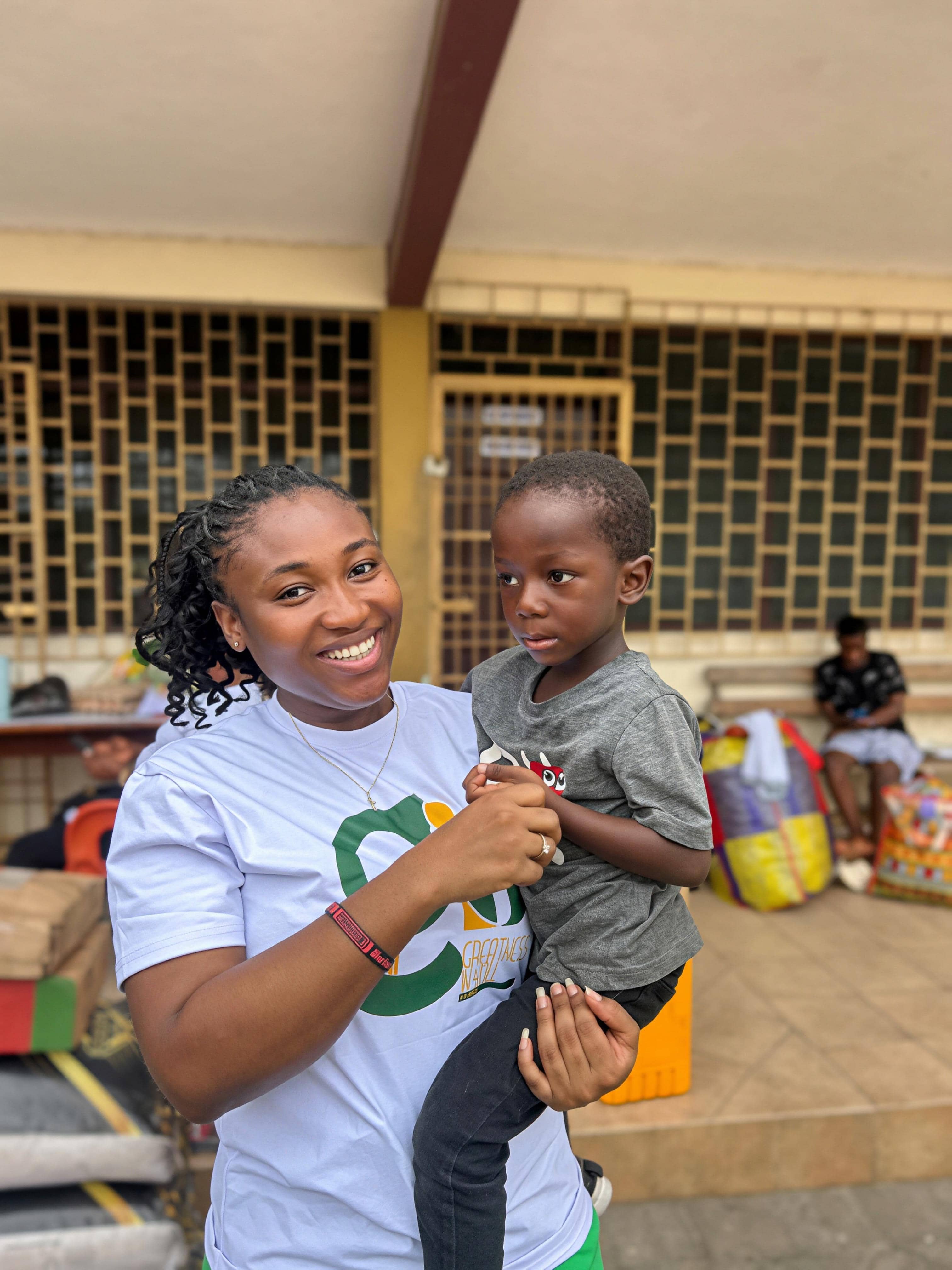 GIU partner Ama Judith holding a child at Osu Children's Home in Accra