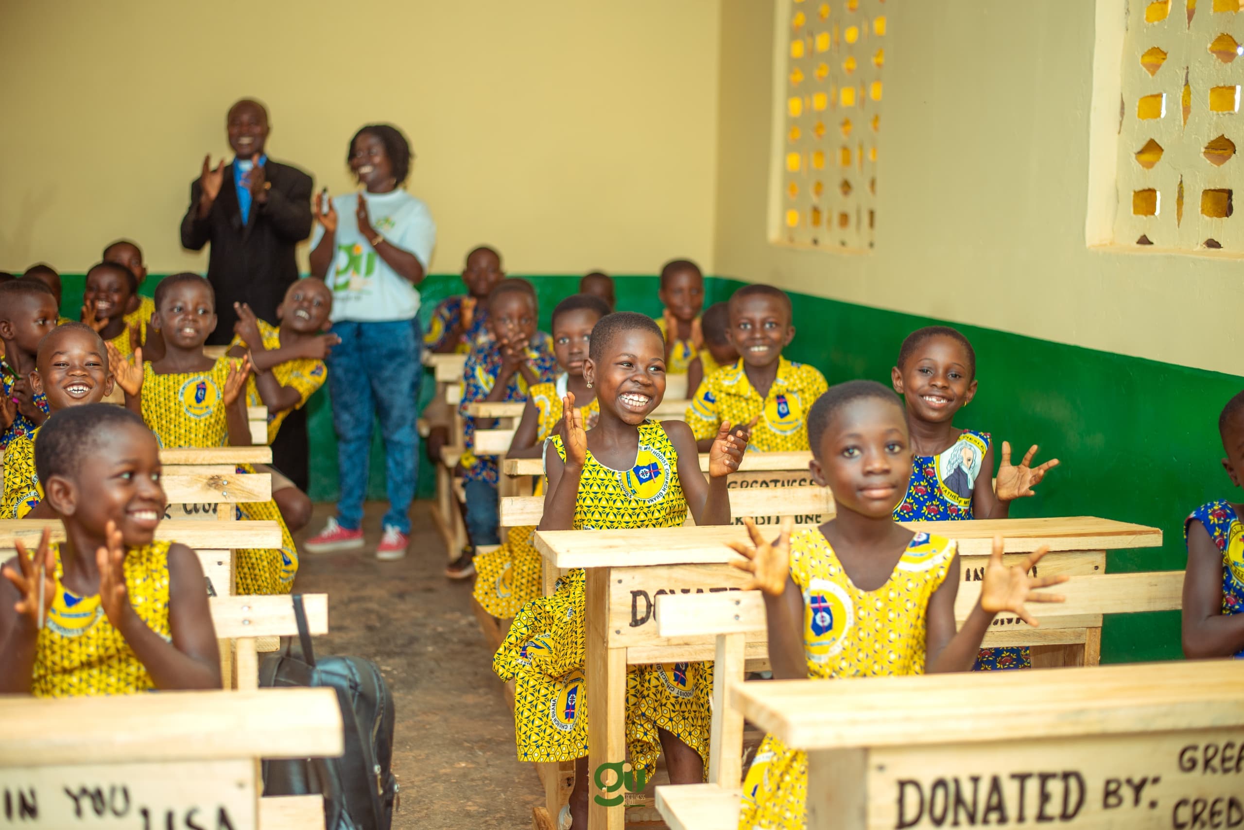 Students sitting at new desks in a GIU-renovated classroom in Ghana