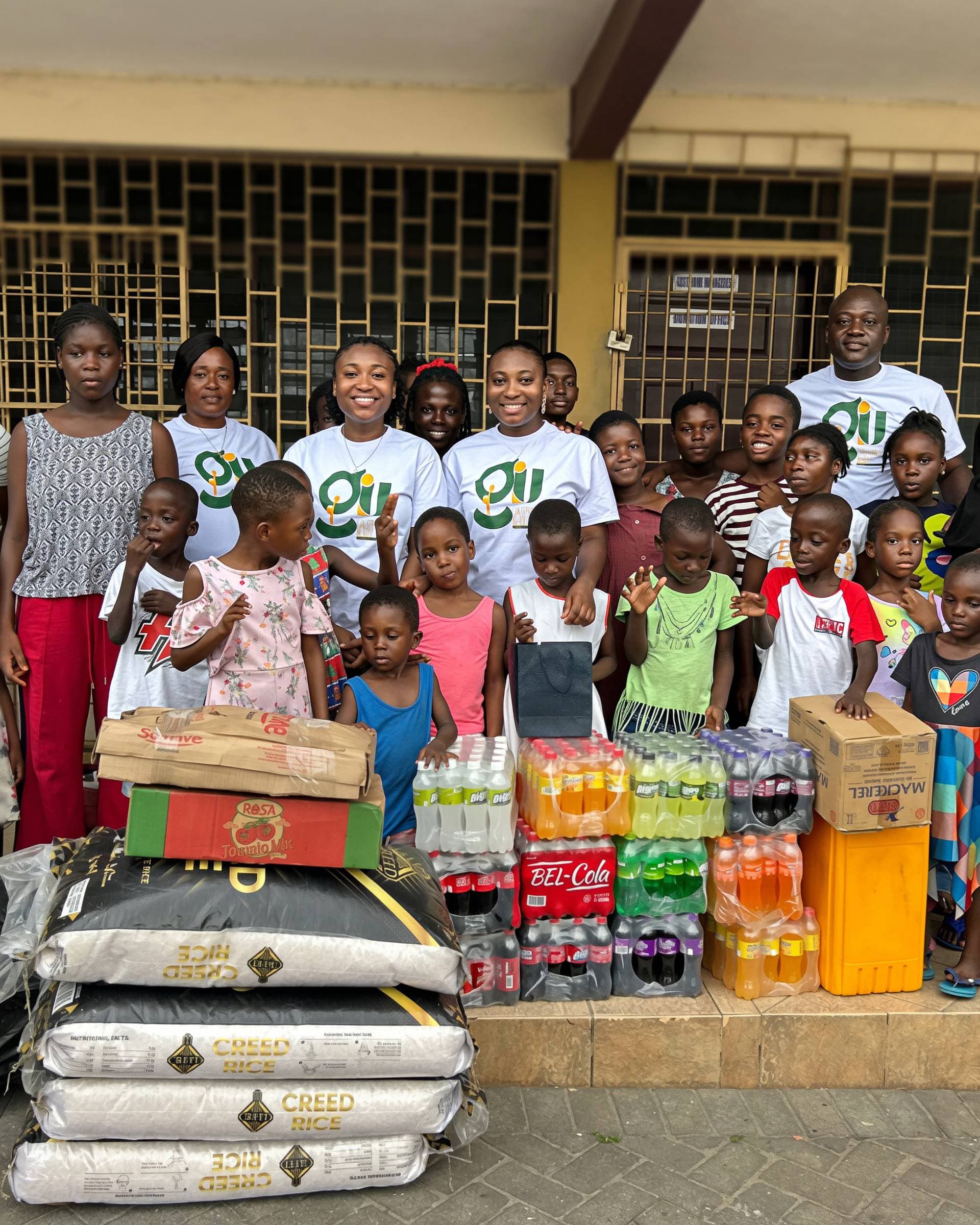 GIU team and Ama Judith donating bags of rice, drinks, and provisions to children at Osu Children's Home